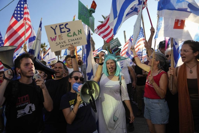 [텔아비브=AP/뉴시스] 11일(현지시각) 이스라엘 텔아비브의 미국 대사관 앞에서 베냐민 네타냐후 총리의 사법개혁에 반대하는 시위대가 미국과 이스라엘 국기를 들고 구호를 외치고 있다. 네타냐후 총리가 사법부 권한 축소 입법을 강행하자 이에 반대하는 역대 최대 규모의 시위가 이스라엘 전역에서 열렸다. 2023.07.12.