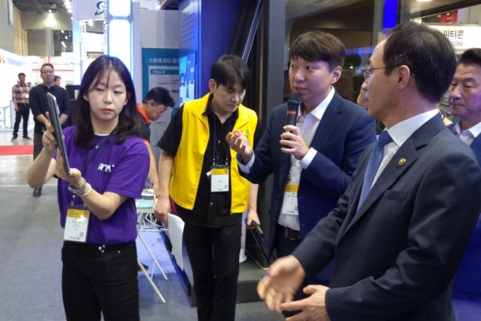 김오진 국토교통부 제1차관(오른쪽)이 김현배 딥파인 대표(오른쪽 두번째)에게 실내AR내비 기능이 포함된 RTA 솔루션에 대한 설명을 듣고 있다. /사진=딥파인