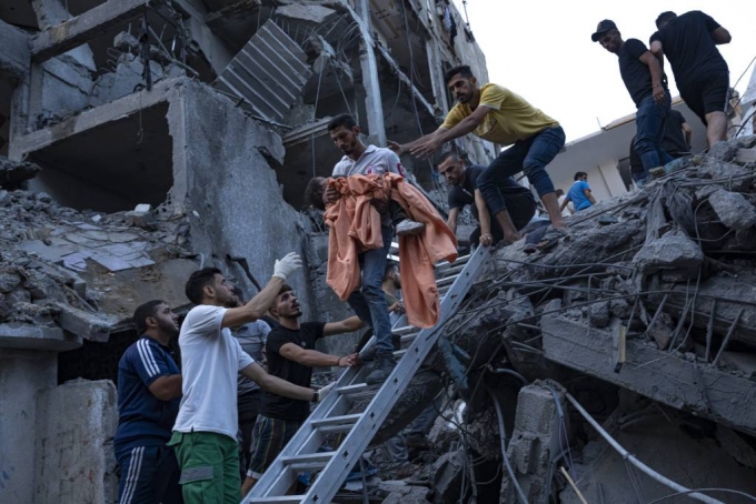 [가자지구=AP/뉴시스] 10일(현지시각) 팔레스타인 가자지구에서 팔레스타인 주민들이 이스라엘의 공습으로 파괴된 주택 건물 잔해 속에 갇혔던 소녀를 구조하고 있다. 이스라엘군(IDF)은 가자지구에 대한 공습으로 하마스 고위 간부 2명을 사살했다고 밝혔다. 2023.10.11.