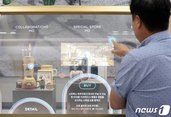지난 8월 서울 강남구 코엑스에서 열린 K-Display 2023 한국디스플레이산업전시회에서 참관객이 LG디스플레이와 스타벅스가 협업한 투명 OLED 제품를 관람하고 있다. /사진=뉴스1