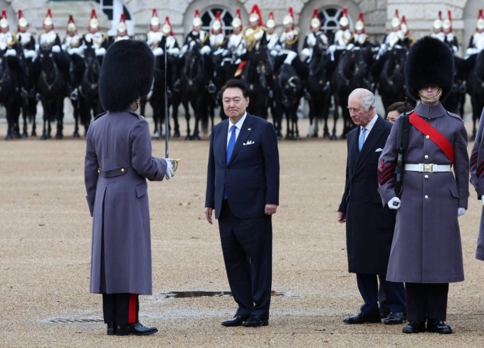 [런던=뉴시스] 전신 기자 = 영국을 국빈 방문 중인 윤석열 대통령이 21일(현지시간) 런던 호스가즈 광장에서 열린 공식환영식에서 찰스 3세 국왕과 함께 의장대를 사열하고 있다. 2023.11.21.