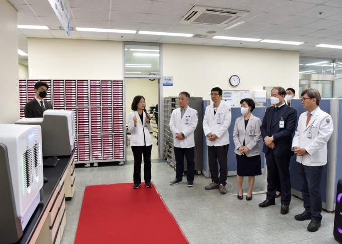화순전남대병원 이경화 병리과장이 정용연 병원장(오른쪽 첫 번째) 등에게 디지털 스캐너 장비에 대해 설명하고 있다./사진=화순전남대병원 