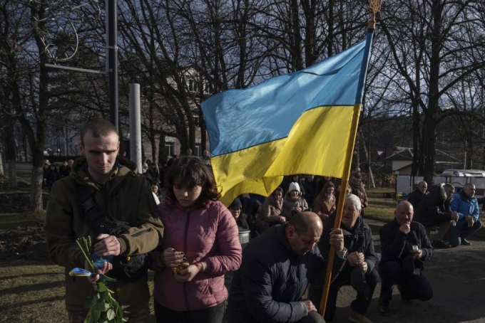 [베르호빈스카=AP/뉴시스] 26일(현지시각) 우크라이나 베르호빈스카에서 우크라이나 군인 바실 보이추크의 장례식이 열리는 동안 주민들이 무릎을 꿇고 고인을 배웅하고 있다. 바실은 2022년 3월 므콜라이우에서 전사했다. 2023.12.27.
