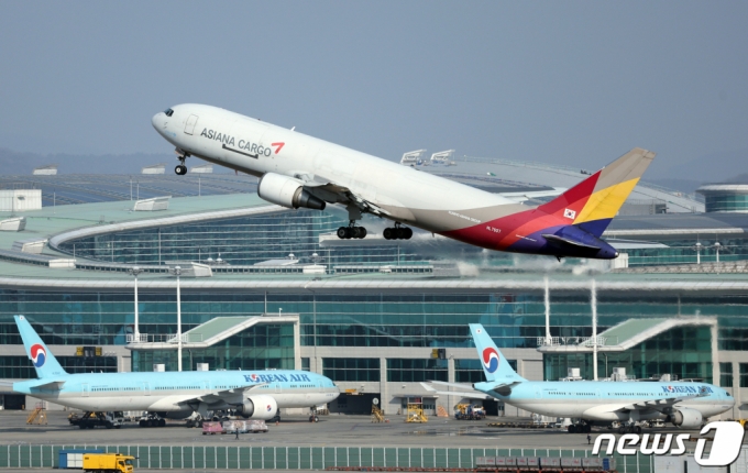 지난달 26일 오후 인천국제공항 계류장에 대한항공과 아시아나항공의 항공기가 지나고 있다.  /사진=뉴스1