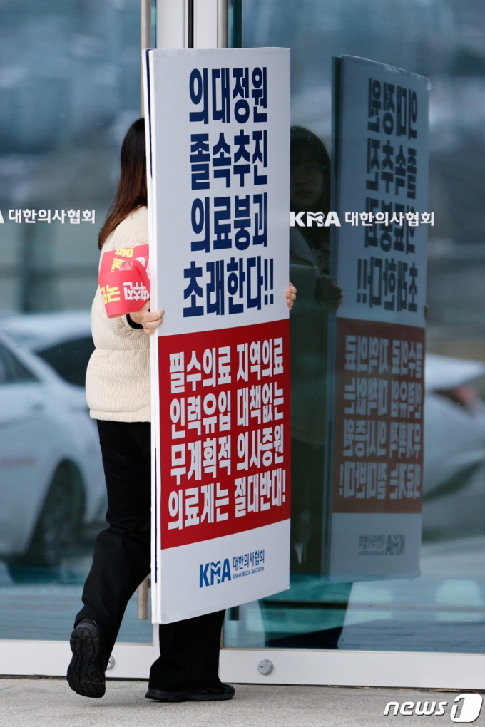 2025학년도 의대 증원규모 정부 발표를 앞둔 지난 6일 서울 용산구 대한의사협회에서 의사증원에 반대하는 피켓을 든 관계자가 출입하고 있다. /사진= 뉴스1
