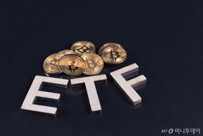 Bitcoin coins with ETF text put on dark background, Concept of the approval of Exchange Traded Fund.
