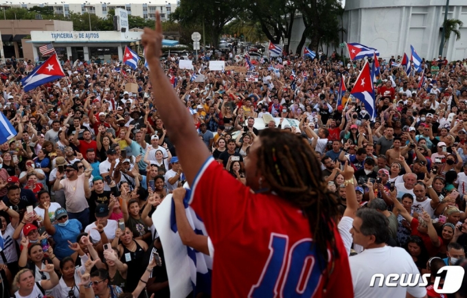 (아바나 AFP=뉴스1) 우동명 기자 = 가수 요투엘 로메로가 11일(현지시간) 공산국가인 쿠바의 아바나에서 거리로 몰려 나와 "독재 타도" "자유를 원한다"를 외치며 미겔 디아스카넬 대통령에 항의하는 반정부 시위대 앞에서 연설을 하고 있다.   (C) AFP=뉴스1  