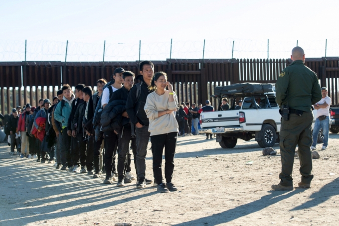 미국 국경 순찰대원들이 국경 장벽을 통해 불법으로 입국한 이민자들을 미국 캘리포니아주 자쿰바의 입국장으로 데려가기 전 줄을 세우고 있다. 조 바이든 미국 대통령과 도널드 트럼프 전 대통령이 오는 29일 멕시코와 인접한 미국 국경 지역을 동시에 찾을 계획이다. /AFPBBNews=뉴스1
