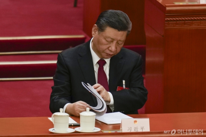 [베이징=AP/뉴시스] 시진핑 중국 국가주석이 5일(현지시각) 중국 베이징의 인민대회당에서 열린 제14기 전국인민대표대회(전인대) 개회식에 참석해 자료를 들춰보고 있다. 2024.03.05. 