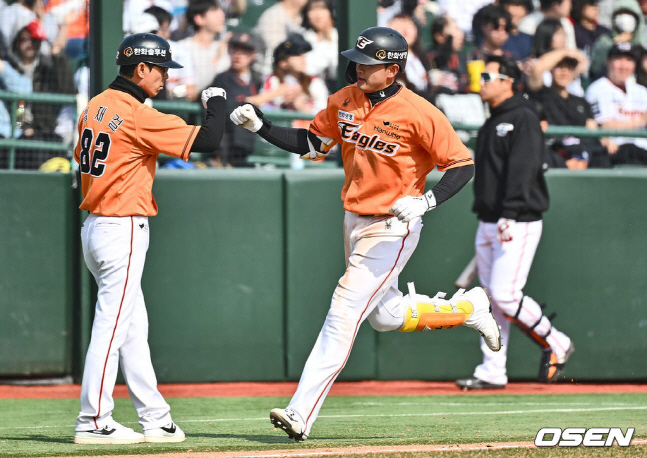 임종찬(오른쪽)이 지난 16일 롯데 자이언츠와 시범경기에서 홈런을 날리고 3루에서 김재걸 코치와 하이파이브를 하고 있다.