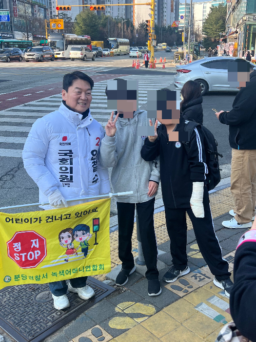 안철수 국민의힘 의원이 20일 오전 성남송현초등학교 사거리에서 교통봉사 중 학생들의 사진촬영 요청에 응하고 있다. /사진=박소연 기자