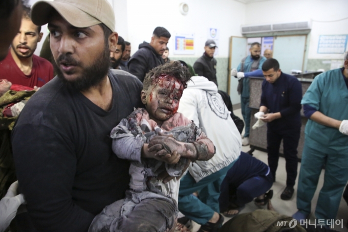 [라파=AP/뉴시스] 24일(현지시각) 이스라엘의 폭격으로 부상한 팔레스타인 소년이 가자지구 라파의 한 병원으로 이송되고 있다. 2024.03.25. /사진=민경찬