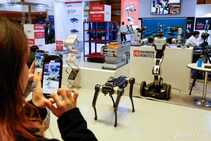 27일 서울 강남구 코엑스에서 열린 아시아 대표 스마트공장?자동화산업전(Smart Factory+Automation World 2024)을 찾은 관람객들이 레인보우 로보틱스 부스에서 로봇을 촬영하고 있다.  /사진=뉴스1