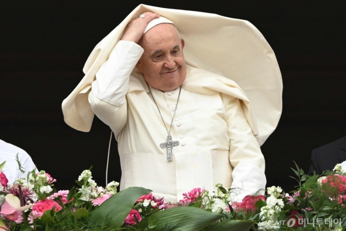 프란치스코 교황이 31일(현지시간) 최대 축일인 부활절을 맞아 바티칸 성 베드로 대성당에서 메시지를 낭독하는 동안 거센 바람 때문에 망토가 날리고 있다./사진=AFP통신, 뉴스1 /사진=(바티칸 AFP=뉴스1) 우동명 기자