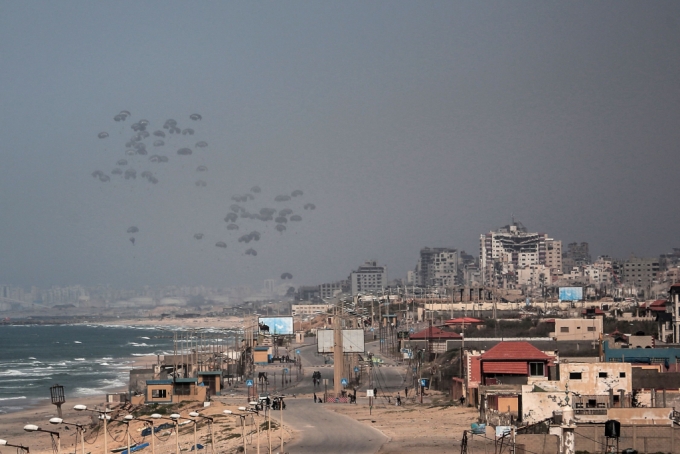 지난 21일(현지시간) 이스라엘과 팔레스타인 하마스 간 폭력 사태가 계속되는 가운데 중부 가자지구 상공에서 낙하산에 부착된 인도적 구호품이 군용기에서 공중 투하되고 있다./AFPBBNews=뉴스1