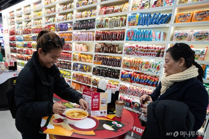 서울 마포구 CU홍대상상점에 마련된 '라면 라이브러리'를 찾은 외국인 관광객들이 라면을 조리해 옮기고 있다.  /사진제공=뉴스1