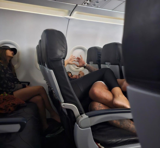 한 항공기 좌석에 커플이 뒤엉켜 누워있다. /사진=X 갈무리