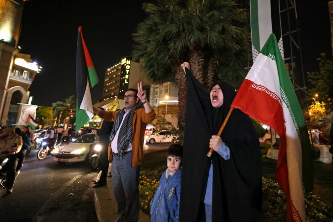 14일(현지시간) 이란 수도 테레란에서 시위대가 이란 국기와 팔레스타인 국기를 흔들고 있다./AFPBBNews=뉴스1