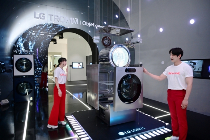 서울 코엑스에서 열리는 월드IT쇼 2024에서 LG전자 모델들이 'LG 시그니처 세탁건조기'의 ‘AI DD모터’와 ‘인버터 히트펌프’ 등 핵심 부품을 살펴보고 있다. / 사진 = LG전자 제공