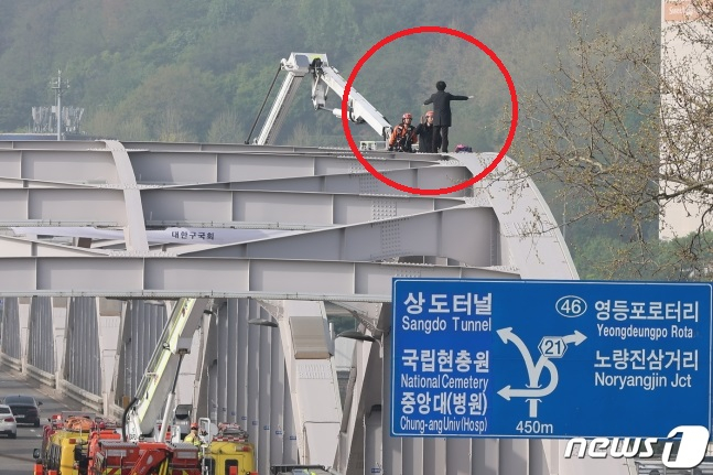 17일 오전 서울 한강대교 노량진 방면에서 신원을 알 수 없는 남성이 교량 위에 올라가 소동을 벌이고 있다./사진=뉴스1