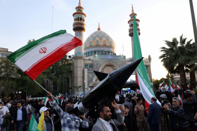 15일(현지시간) 이란 테헤란 시민들이 이란의 이스라엘 공습을 자축하며 미사일 모형을 운반하고 있다./로이터=뉴스1