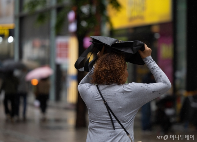 서울 중구 명동거리에서 우산을 준비하지 못한 외국인 관광객이 발걸음을 재촉하고 있다./사진=뉴스1