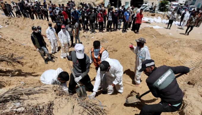 팔레스타인 민방위대 구조대원들이 21일(현지시간) 가자지구 칸유니스 나세르 의료단지 내부에 집단 매장된 시신을 수습하고 있다. /로이터=뉴스1