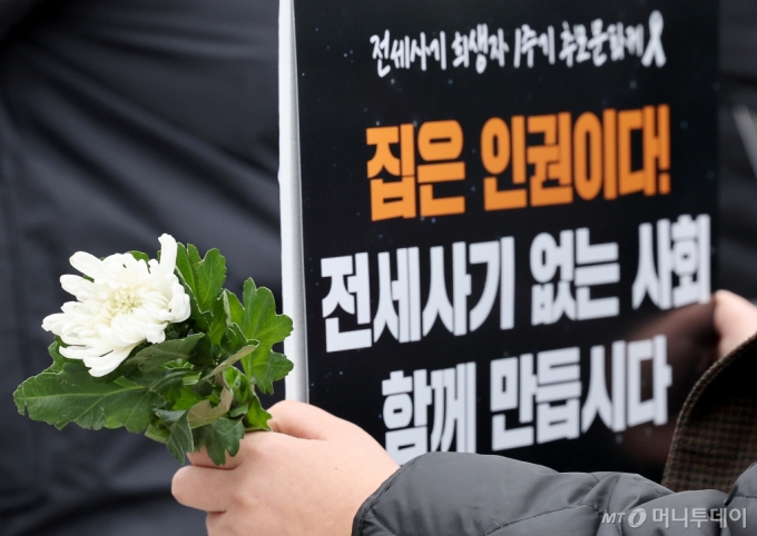 전세사기 희생자 1주기 추모문화제에서 전세사기 피해자가 희생자를 위한 국화꽃을 들고 있다./사진=뉴스1
