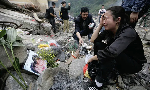 지난 2008년 중국 쓰촨성 베이촨현에서 한 부모가 지진으로 사망한 딸(사진 속 왼쪽)을 애도하고 있다./사진=뉴욕타임스