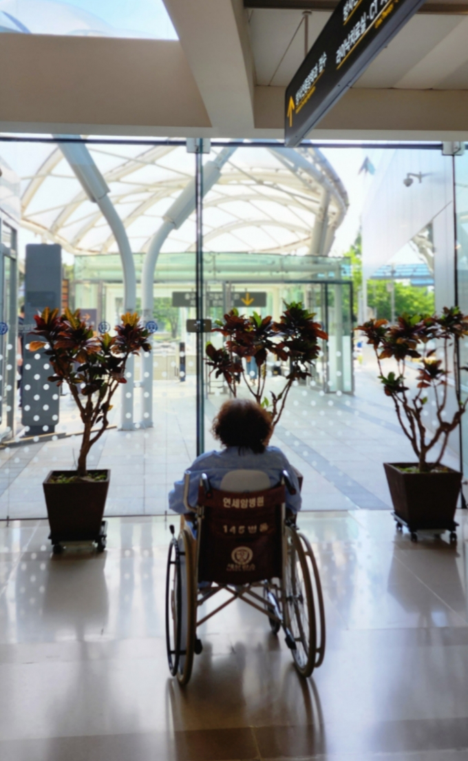 세브란스병원 내 연세암병원에서 방사선 치료를 받고 나온 한 70대 여성 환자가 휠체어를 탄 채 창밖을 바라보고 있다. /사진=정심교 기자