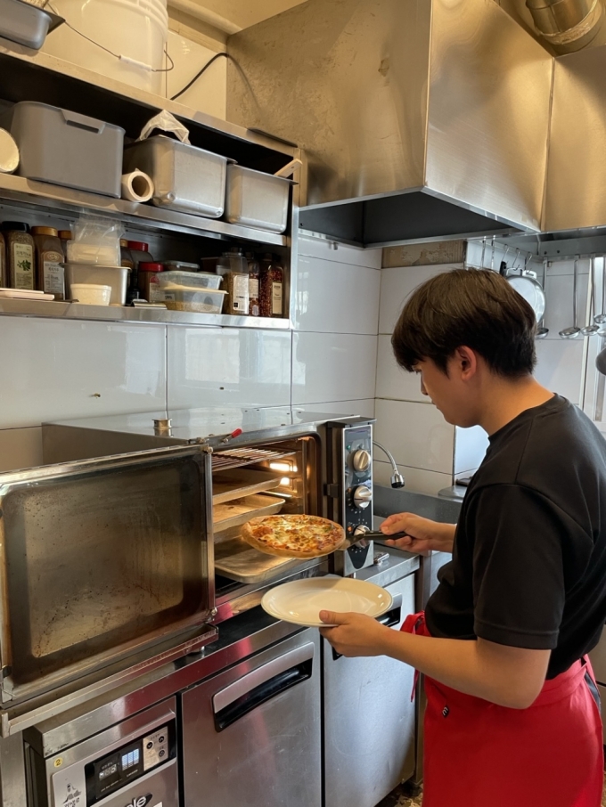 서울 성동구 성수동 골목에 마련된 '요리하다 오스테리아' 팝업스토어 내부 식당에서 직원이 피자를 옮겨담고있다. /사진제공=롯데마트