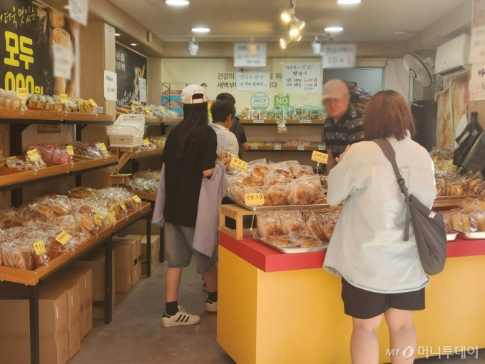 지난 14일 오후 4시30분쯤 서울 마포구 망원시장 내 '천원의 행복 빵집'을 찾은 손님들./사진=최지은 기자
